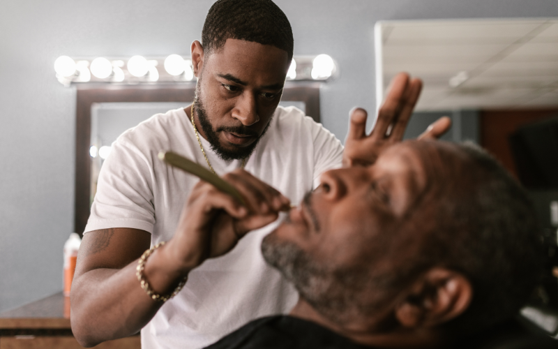 Barbershop interior with styling chairs, mirrors, lighting, and countertop appliances — common sources of electrical and ventilation concerns.